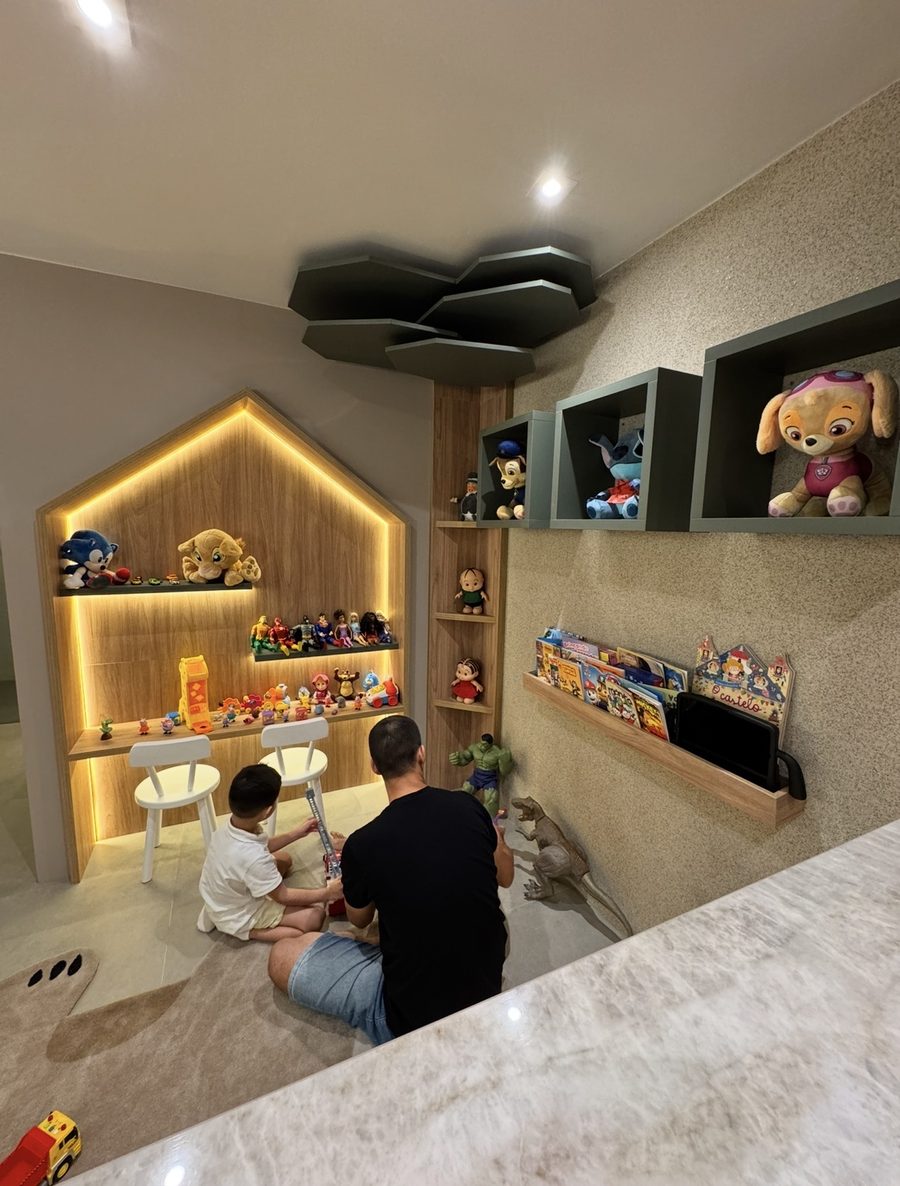 Pai e filho brincando no espaço infantil do consultório do Dr. Alfredo Abud
